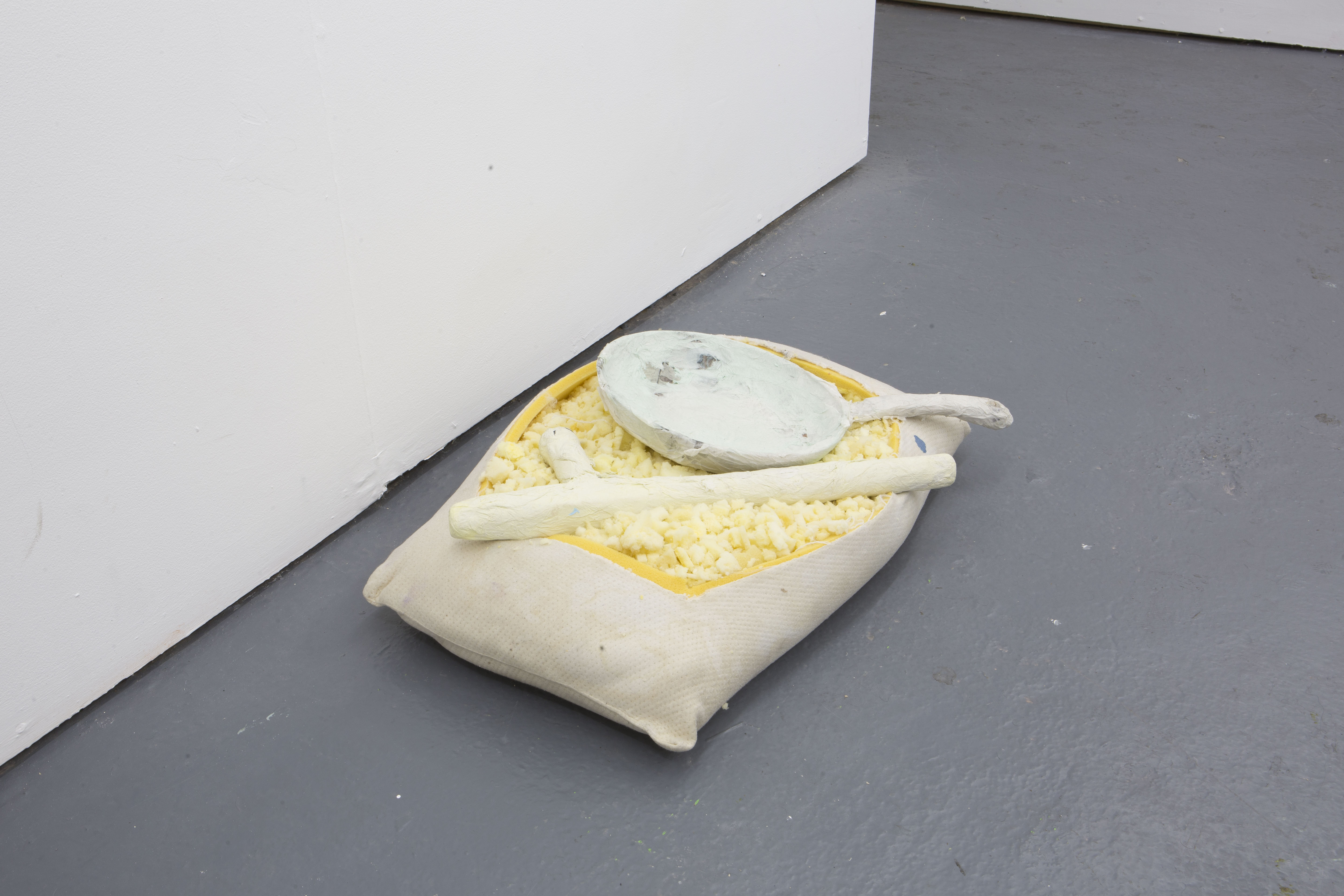 Thomas Greig Treasure (2019); 15x40x60cm; Pillow, truncheon, frying pans, tissue paper, acrylic paint.